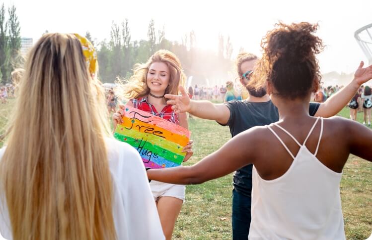 Aquila - company culture with individuals outdoors, one holding a free hugs sign